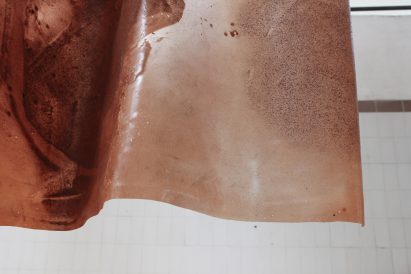 Swirly pattern on reddish-hued Brick Textiles by Natural Material Studio