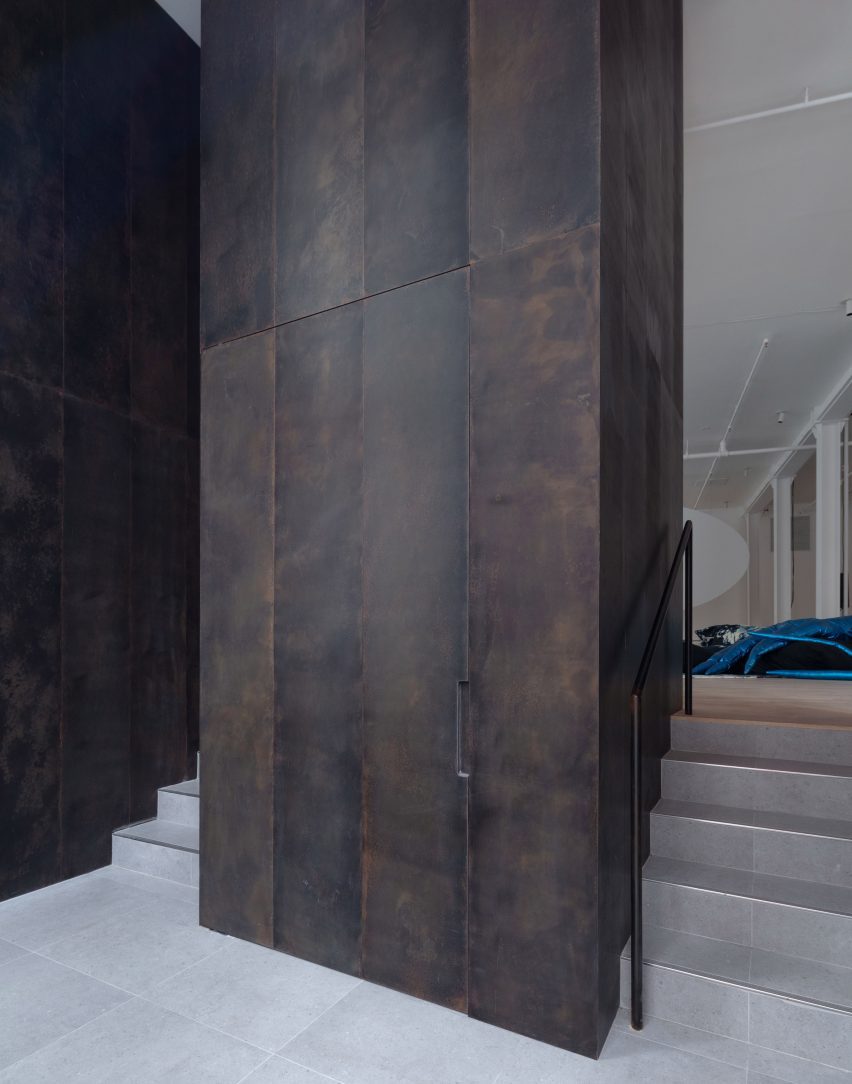 Patinated bronze panels line the entry threshold