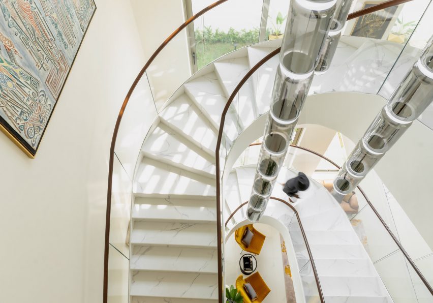 White double-height room with a curving staircase