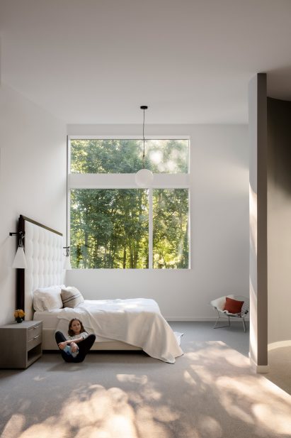 Girl in white bedroom with modern bulb lamp