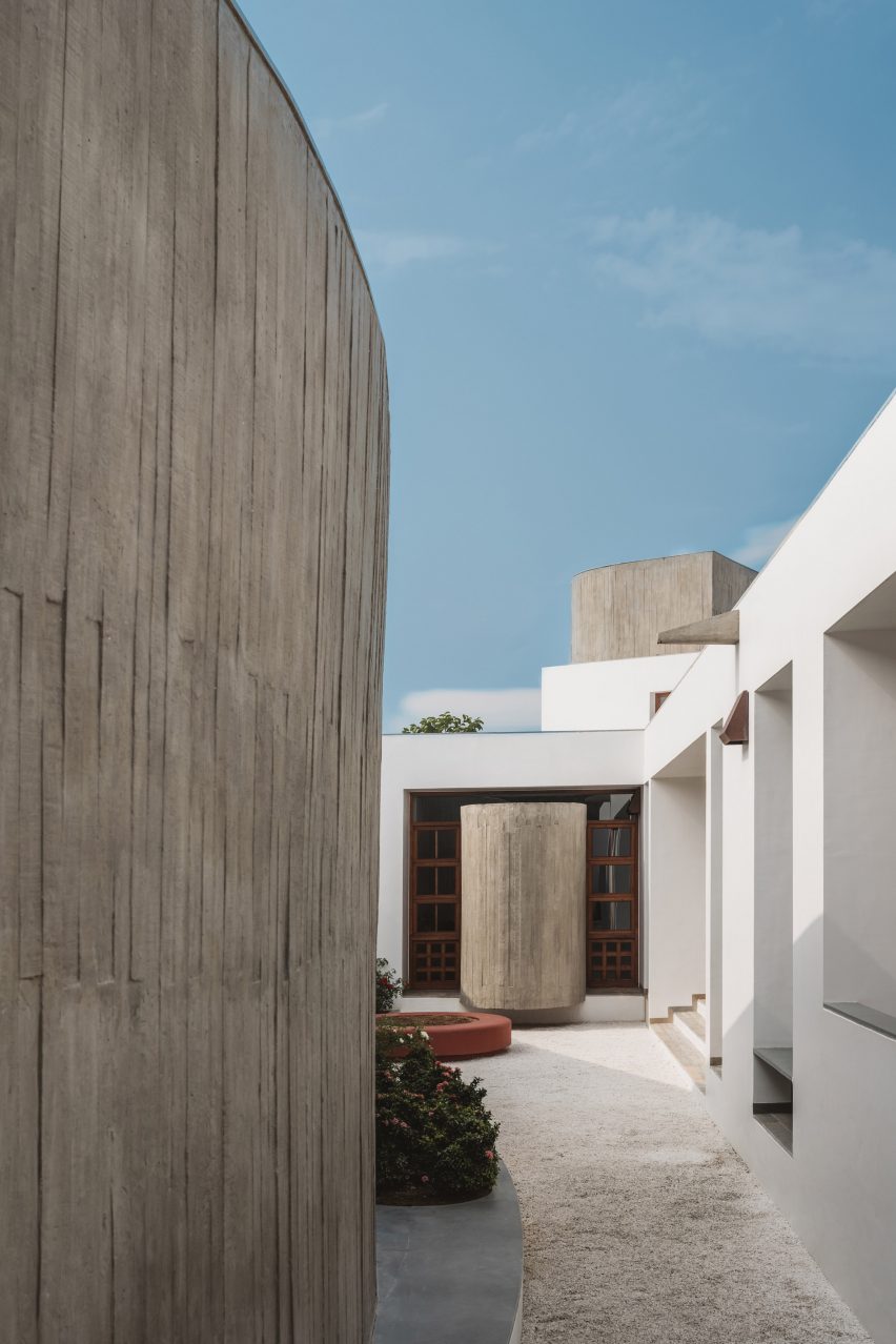Courtyard next to a white house and concrete exterior wall
