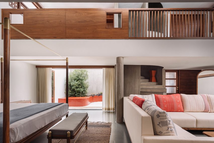 Bedroom with an L-shaped sofa and large opening leading to an outdoor courtyard