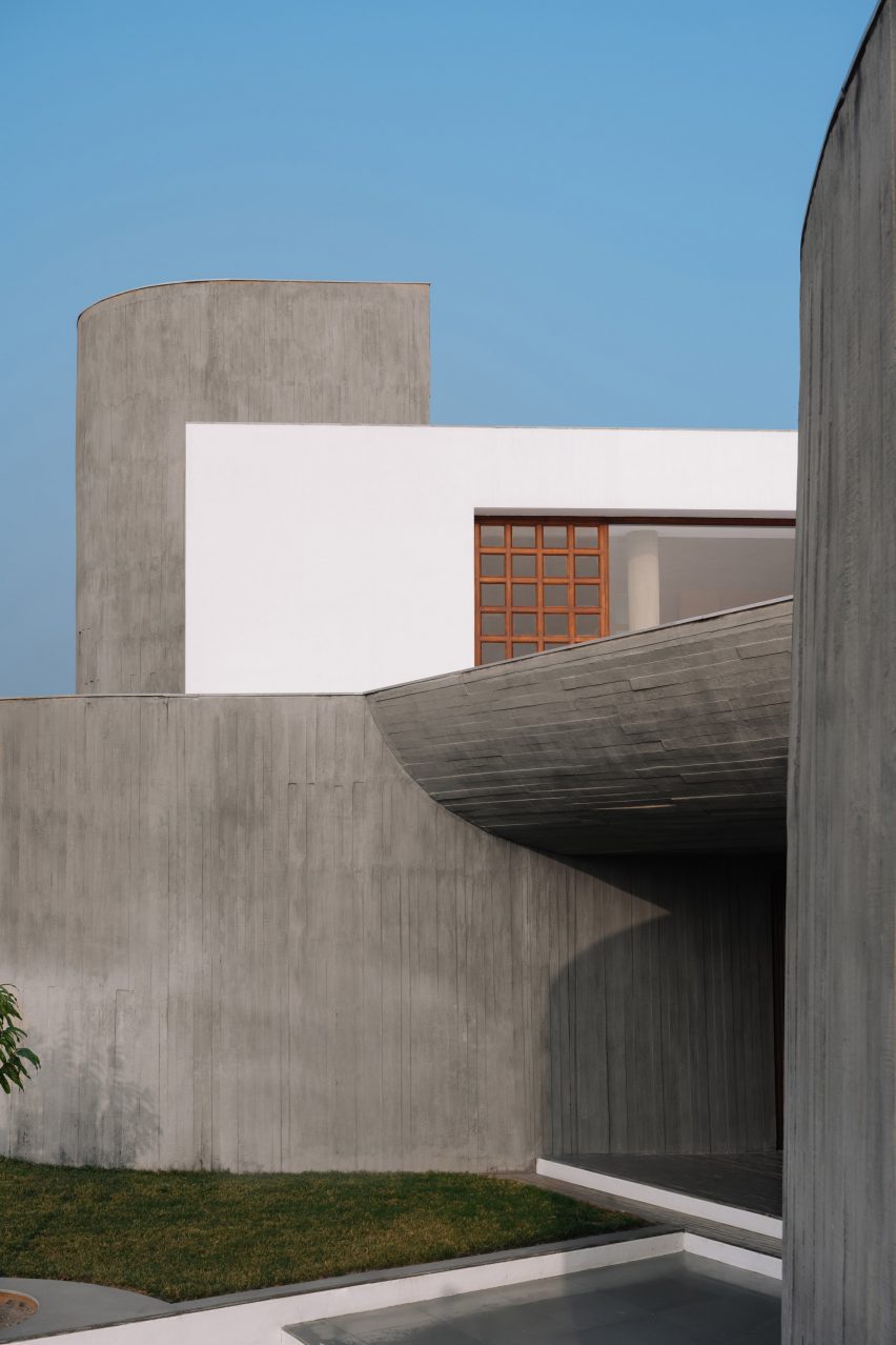 Exterior of a home on a grass mound with board-formed concrete walls