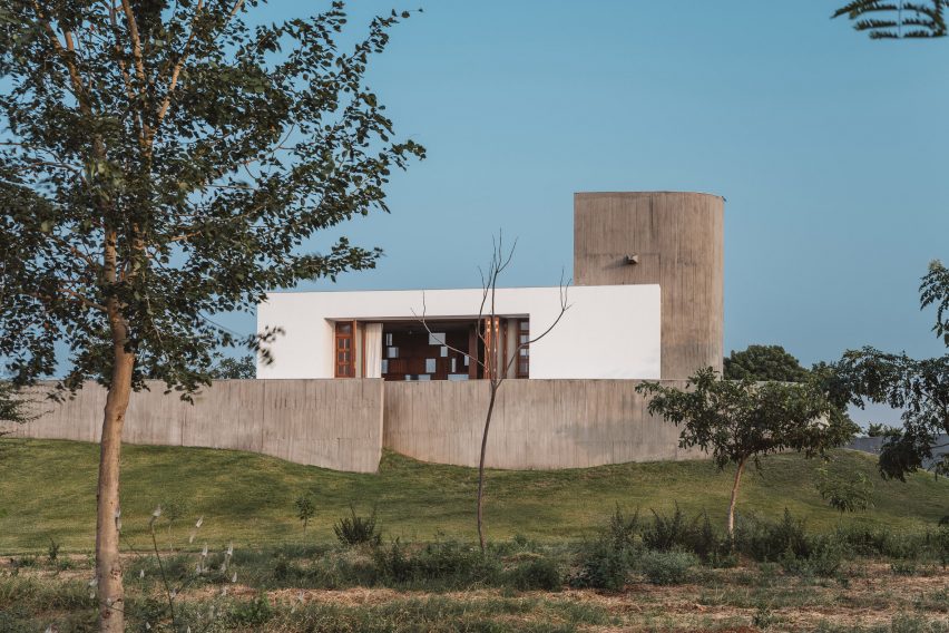 Exterior of a home on a grass mound with board-formed concrete walls