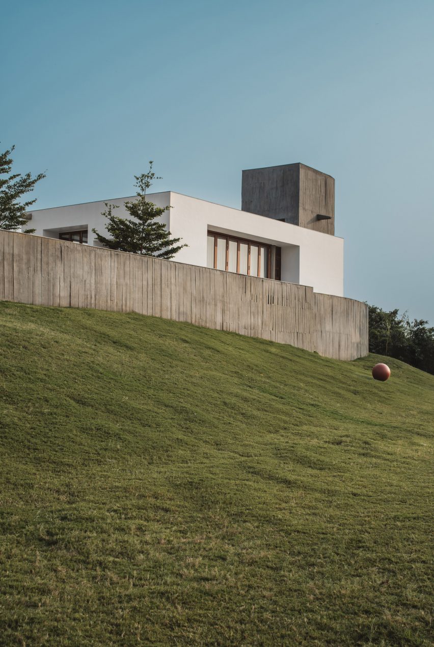 Exterior of a home on a grass mound with board-formed concrete walls