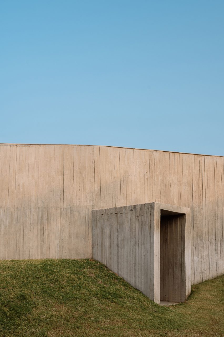 Exterior of a home on a grass mound with board-formed concrete walls