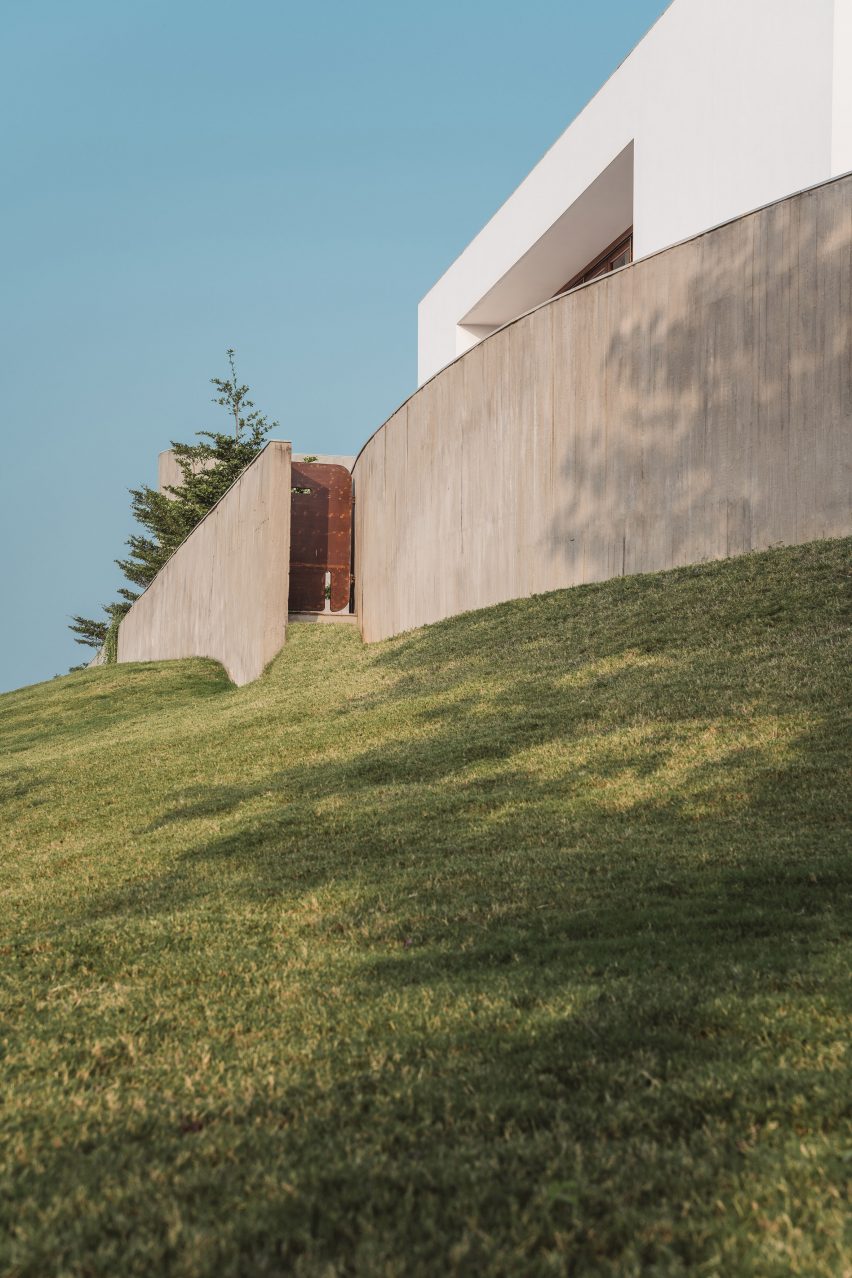 Exterior of a home on a grass mound with board-formed concrete walls