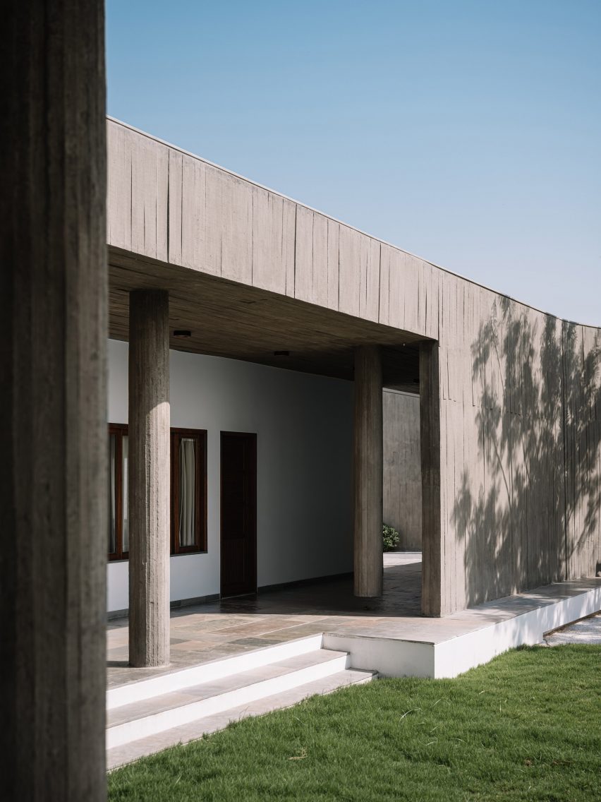 Exterior of a home on a grass mound with board-formed concrete walls