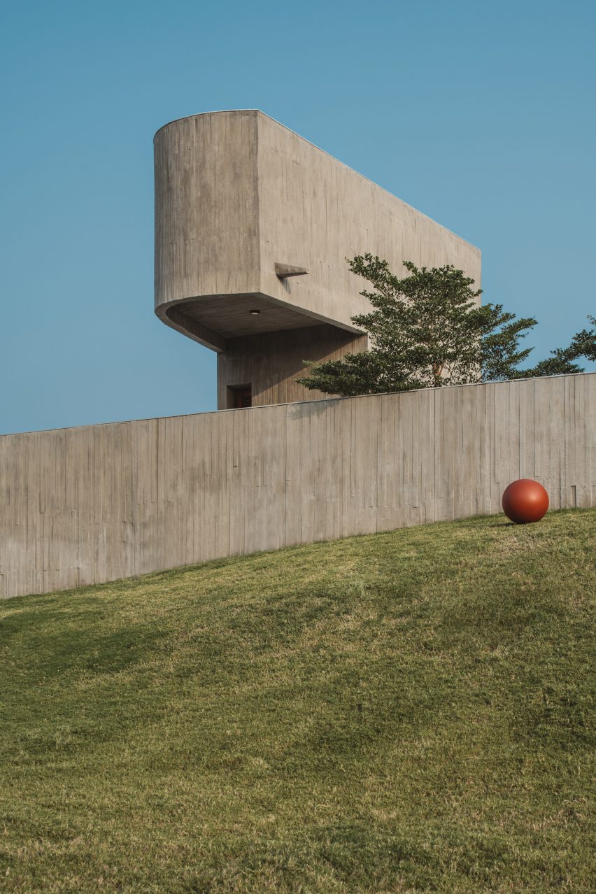 Exterior of a home on a grass mound with board-formed concrete walls