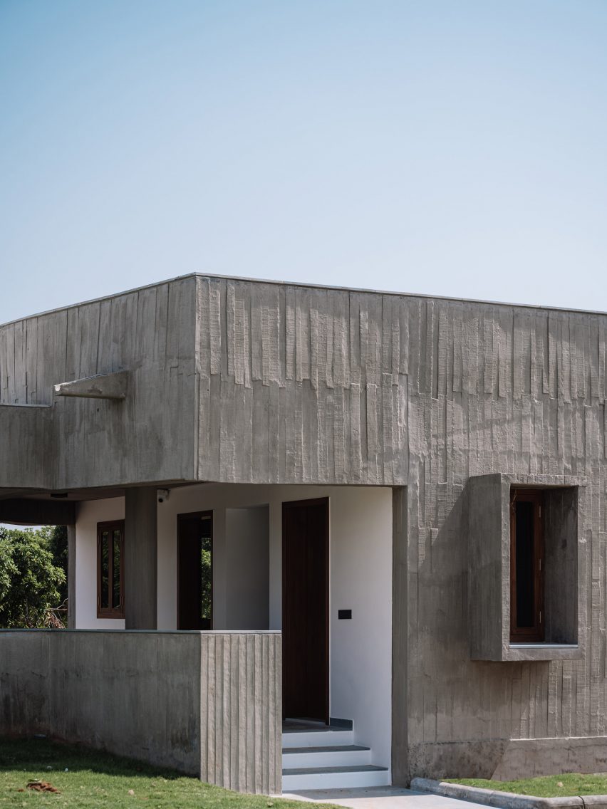 Exterior of a home on a grass mound with board-formed concrete walls