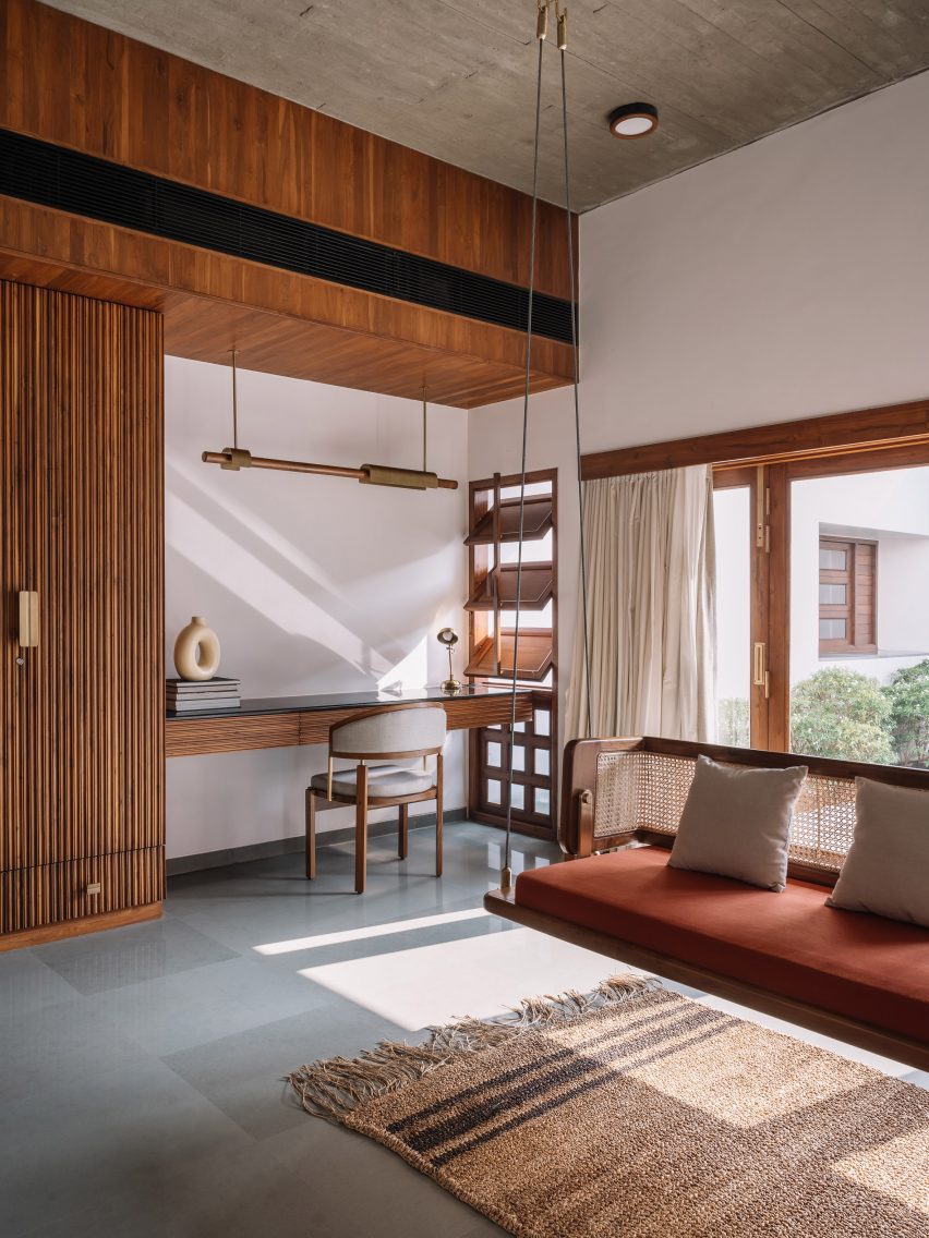 Living area with concrete floors, wood wall panels, a desk and sofa