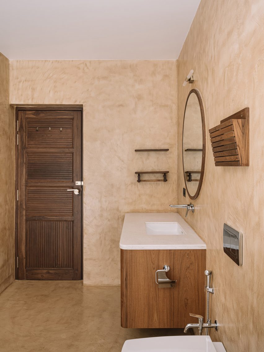 Bathroom with cream walls, brown-tiled floor and wooden vanity unit