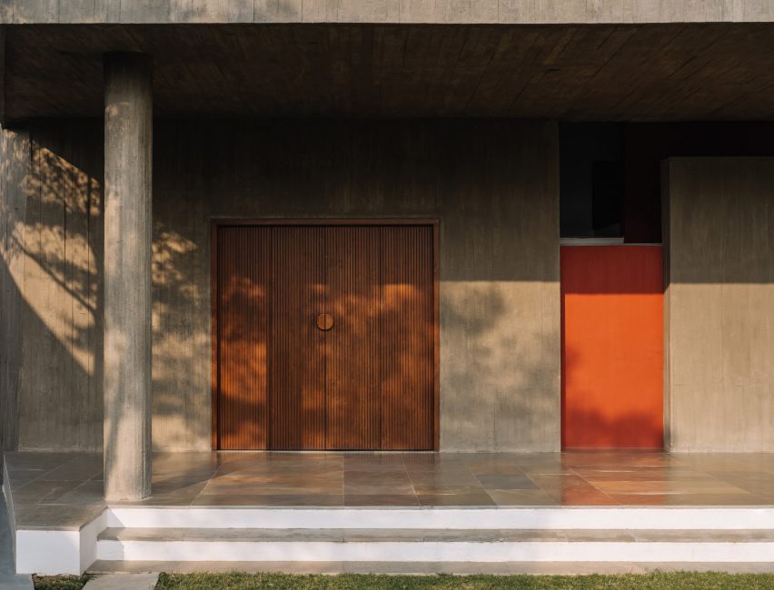 Outdoor porch with concrete walls and floors and wood double doors