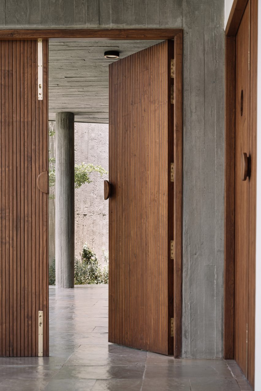 Wooden doorway in a room with polished concrete floors and concrete walls
