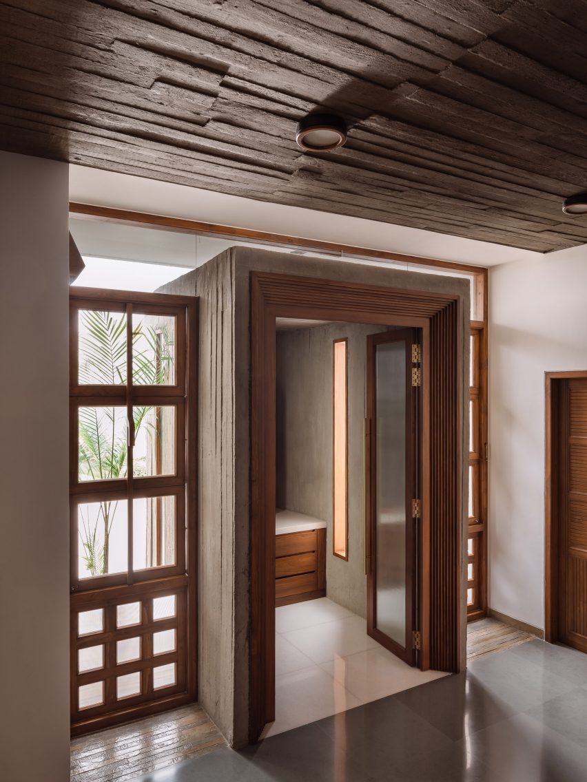 A room with board-formed concrete ceiling and wood-frames windows and doors