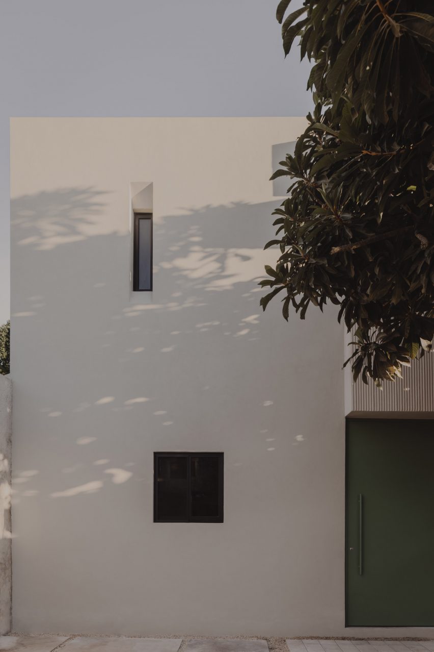 Exterior white wall with two small windows at the El Tiron house by FMT Estudio