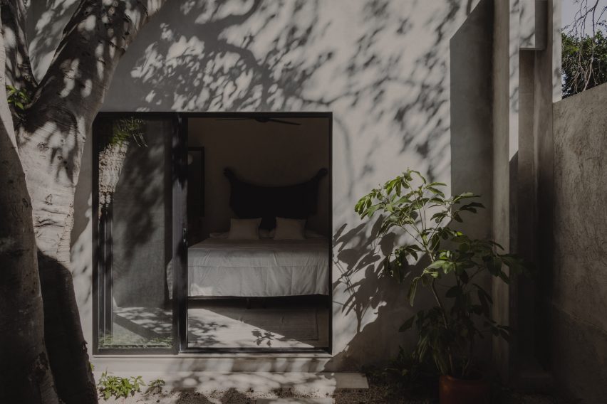 An outdoor patio by a concrete home with slading glass doors leading to a bedroom