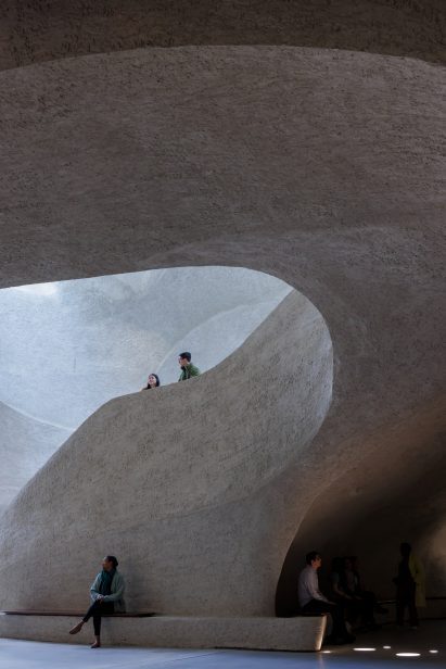 Two people walking down a staircase in the atrium
