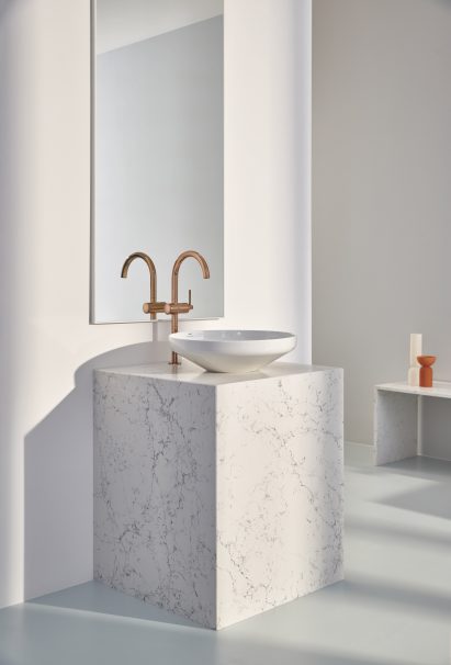 Rose gold tap on white marble pedestal