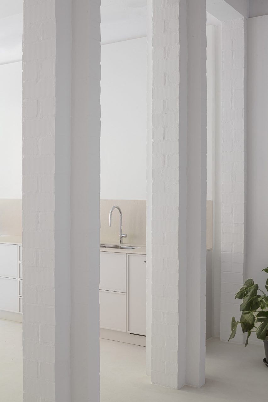 White kitchen with white cabinets and square columns