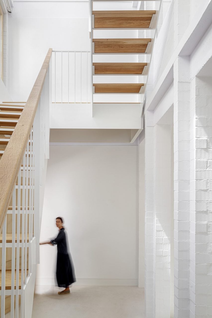 White interior with a a staircase with wood treads and open space between them