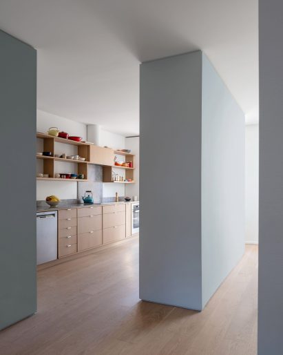 Kitchen separated from dining room by pale blue partition