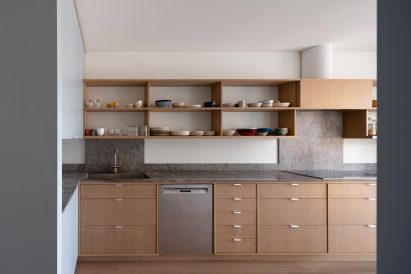 Kitchen with oak cabinetry and marble countertops
