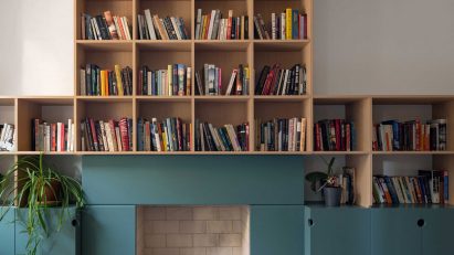 Teal fireplace with oak bookshelves above
