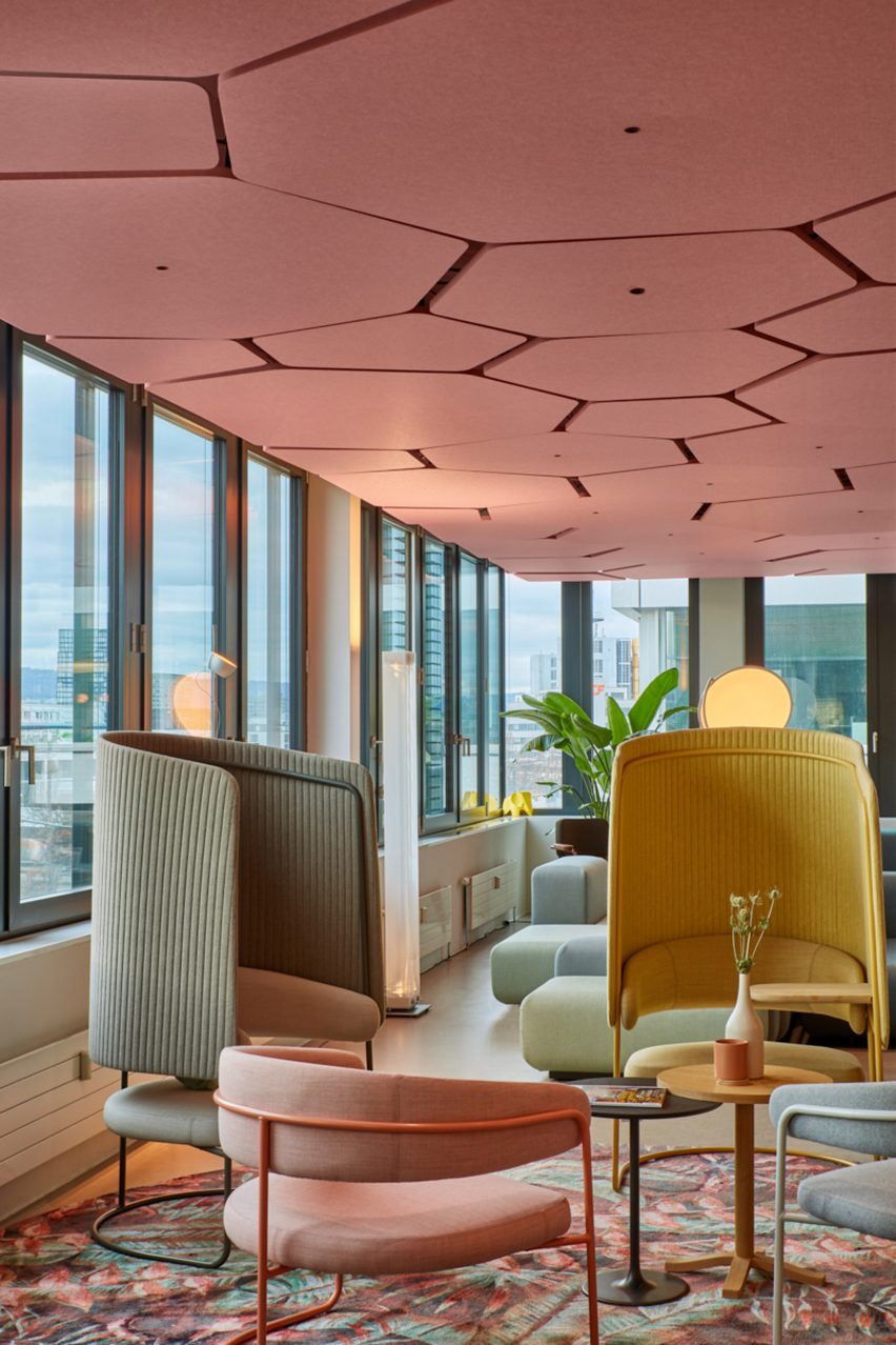 Pink hexagonal ceiling tiles with LED lights in centre in office