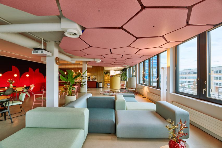 Pink hexagonal ceiling tiles with LED lights in centre in office
