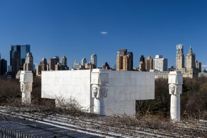 Roof with twigs and the white pillars in foreground with skyline in background