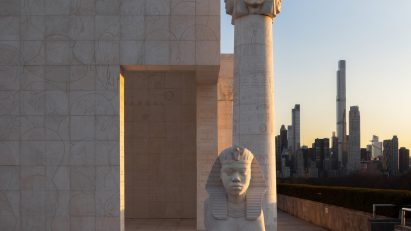 Sunset with Sphinx and pillar and New York skyline behind