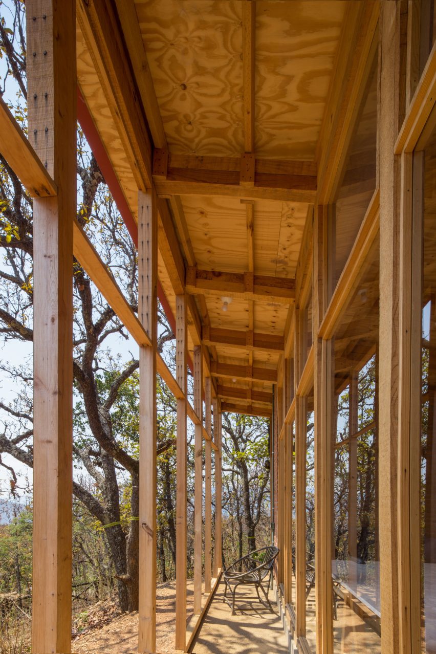 A narrow porch with a wooden structure on a sandy hillside