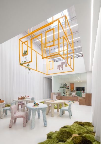 Orange outline of a house suspended above pastel-coloured furniture