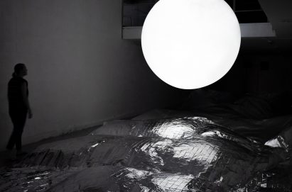 A glowing white sphere reflected in shiny material below