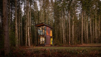 Two storey steel studio with firs in background