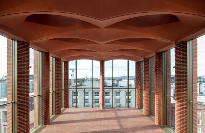 Top floor exhibition space at the International Rugby Experience building by Niall McLaughlin Architects with large windows and arched ceiling