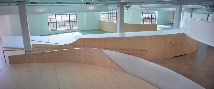 Interior of a musem with wood flooring and curved wooden elevated walkways