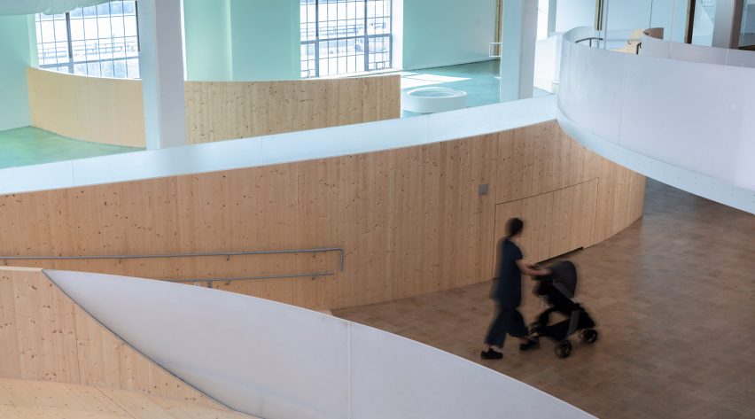 Interior of a museum with wood flooring and curved wooden elevated walkways