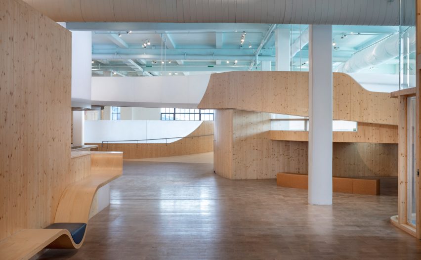 Interior of a museum with wood flooring and curved wooden elevated walkways