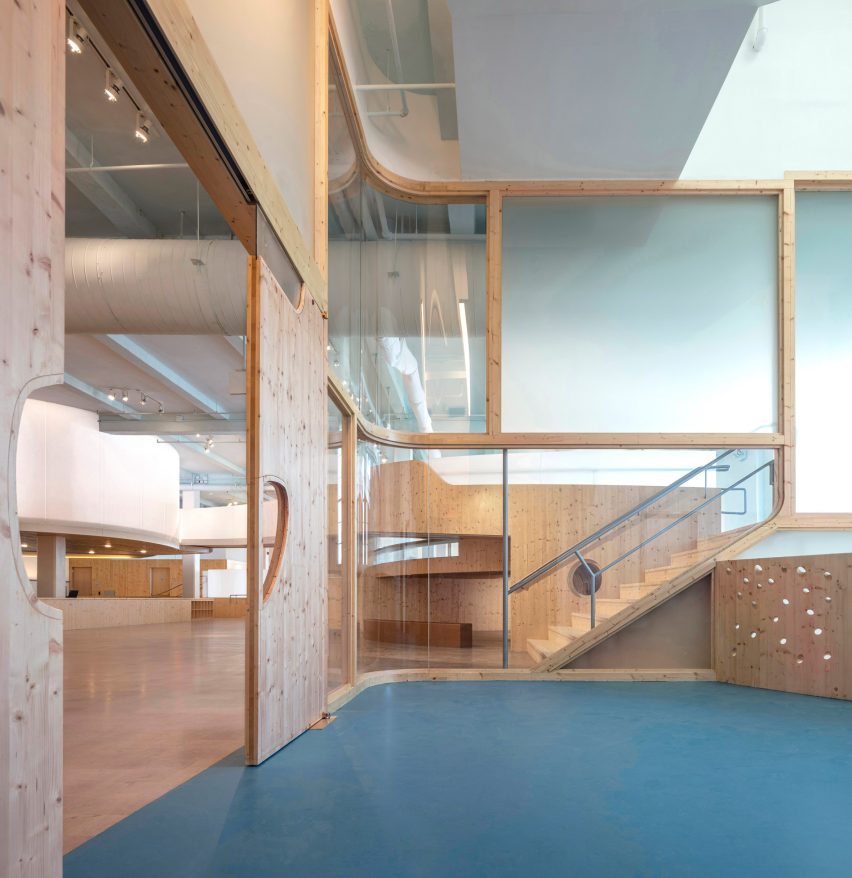 Playroom in a museum with green carpet, square glass windows and a wood sliding door