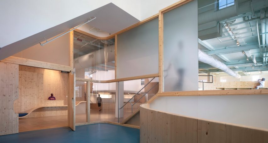 Interior of a playroom with blue carpets and wood and acrylic wall panels
