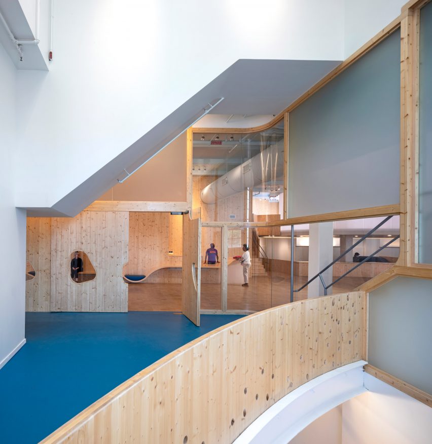 Interior of a playroom with blue carpets and wood and acrylic wall panels