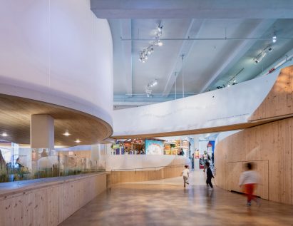 Museum interior with wood floors and overhead curving walkways