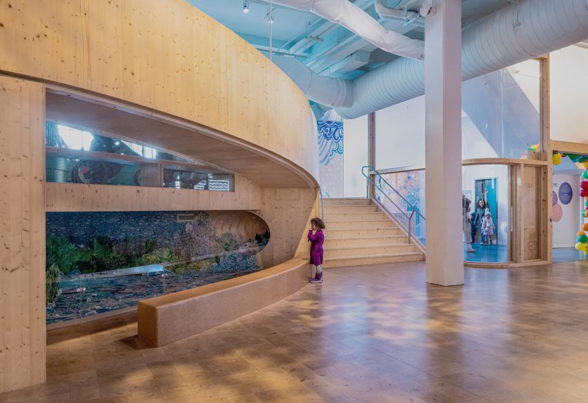 Interior of the Bronx Children's Museum with wood flooring and curved wooden elevated walkways