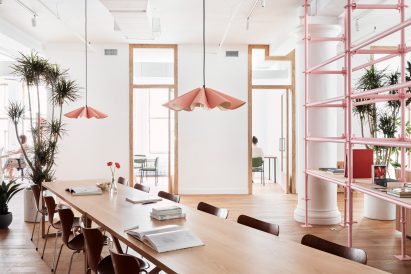 Pleated pendant lights hang above a long table