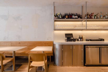 Distressed plaster walls, wooden bench and stainless steel cabinets