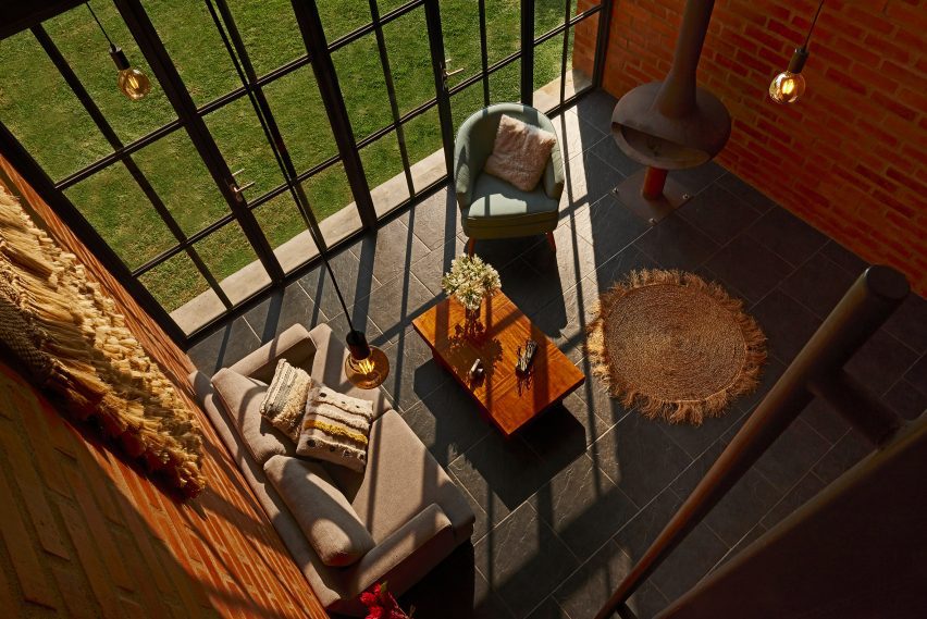 Open-plan living space with brick walls and double-height window facade