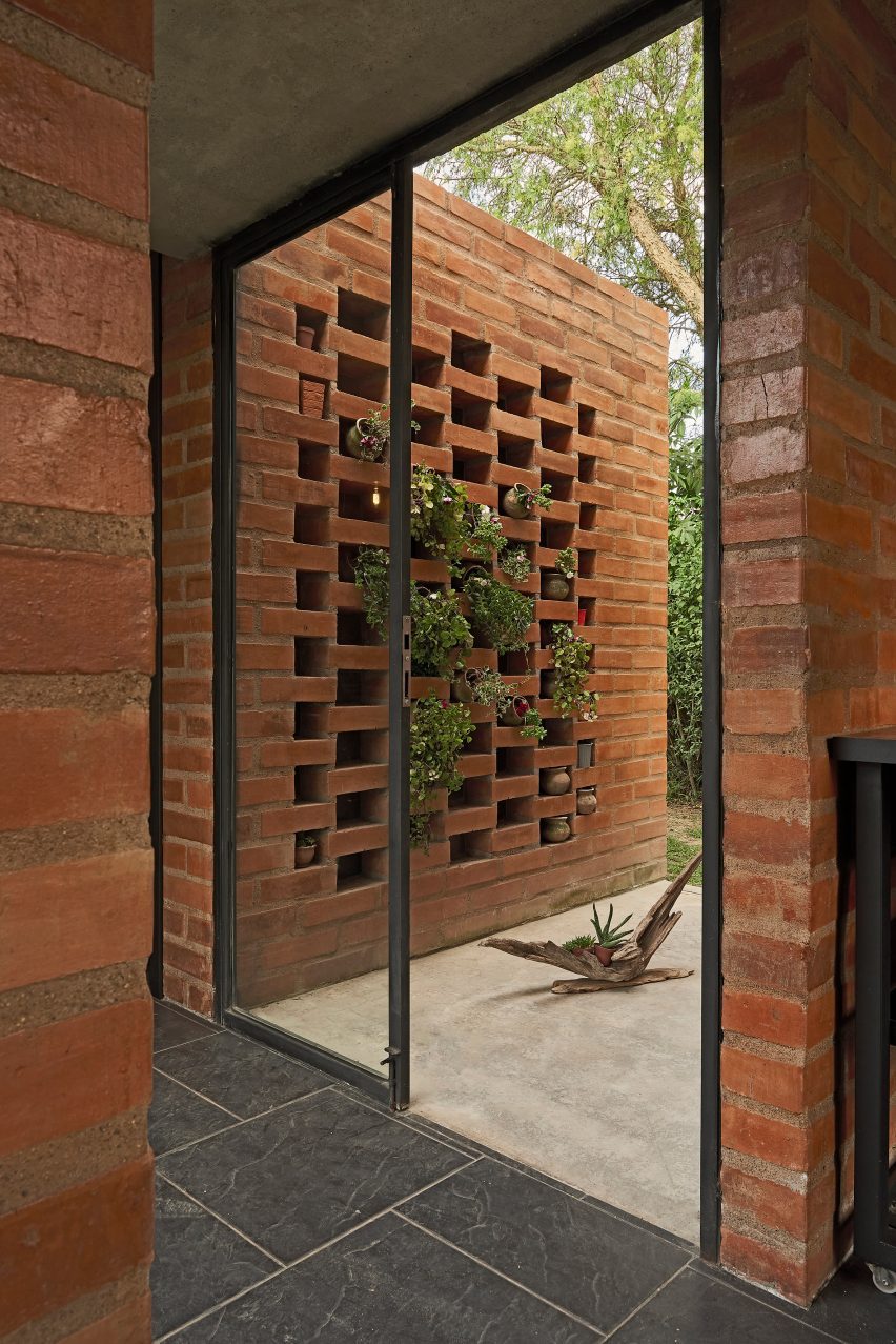 Interior space with brick walls leading to a brick outdoor courtyard