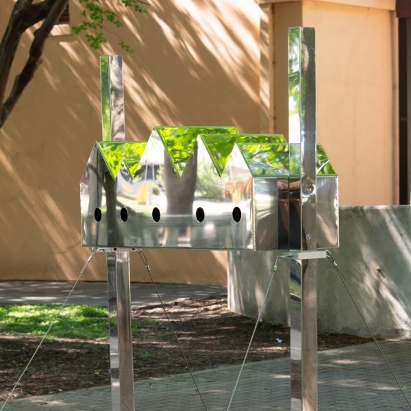 A birdhouse with a series of pitched roofs and reflective surfaces